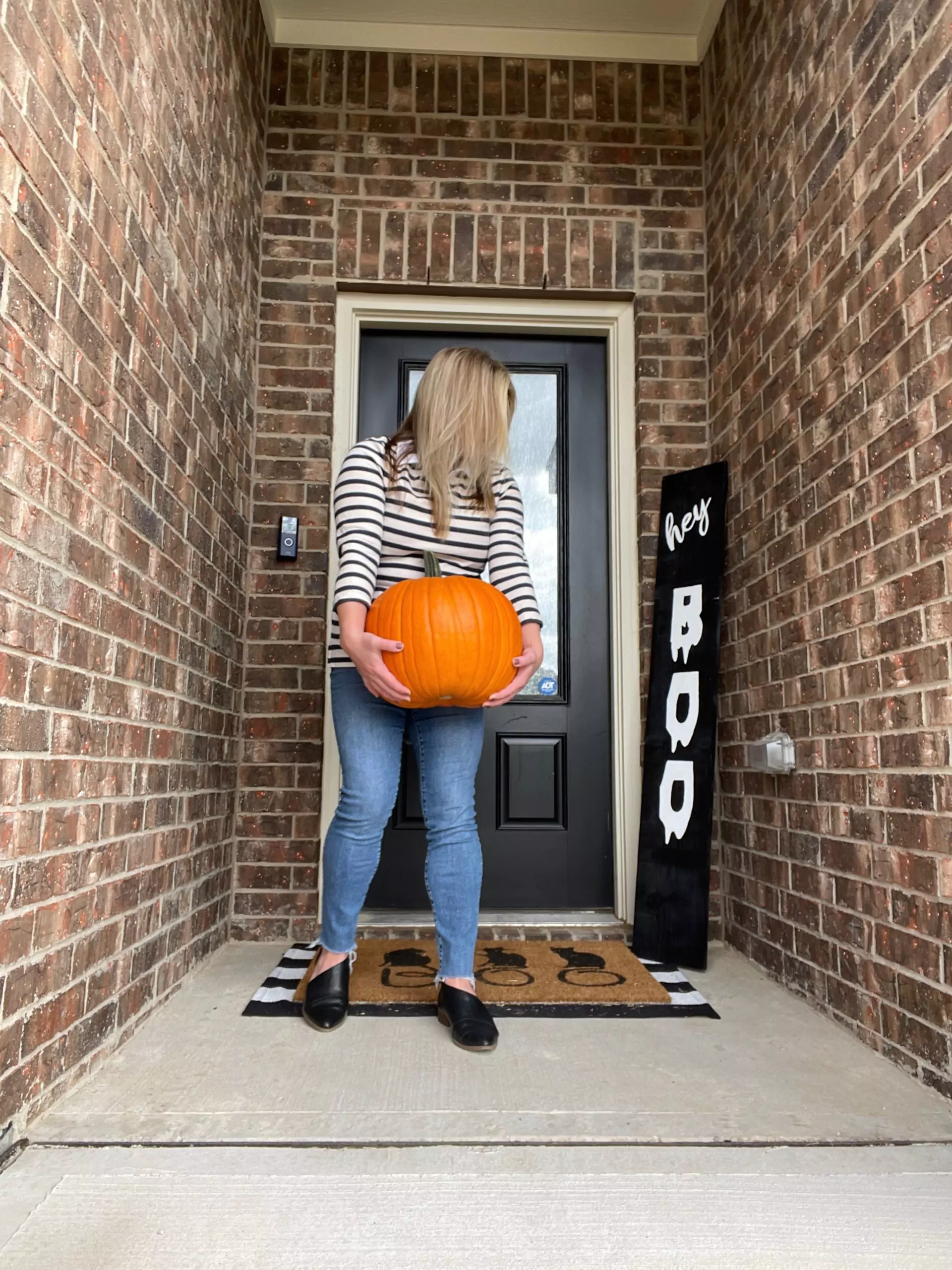 Katie Kinsley Holding pumpkin in front of hovel sweet hovel